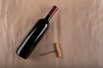 Wine bottle and corkscrew on a brown background. Space for text.