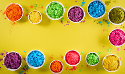 Happy holi festival decoration.Top view of colorful holi powder on yellow  background with copy space for text.