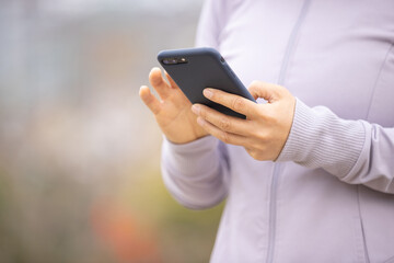 Asian woman using smartphone outdoors