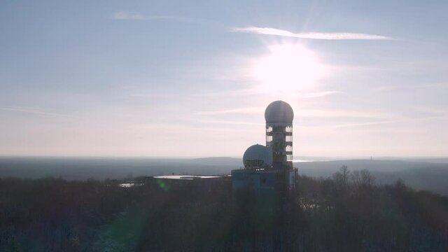 silhouette shot of abandoned observatory station on a hill in winter during sunset