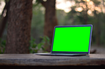 A laptop with a green screen on the table