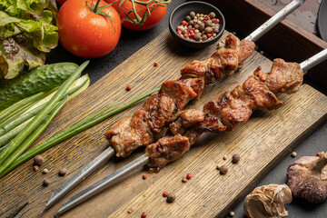Shish kebab on skewers lies on a wooden table