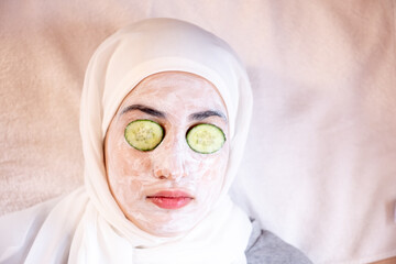 Muslim woman laying down in a spa with facial mask