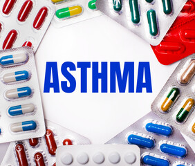 The word ASTHMA is written on a light background surrounded by multi-colored packages with pills....