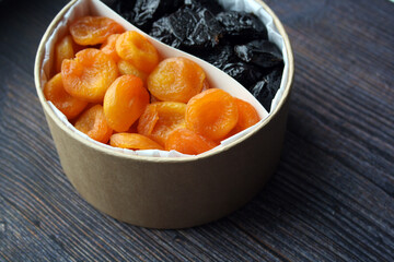 Dried fruits. Dried apricots and prunes on a wooden background.