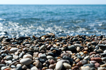 beach stones and pebbles in front of glittering sea