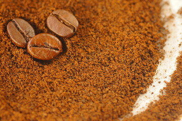 Coffee beans on brown and white background. Coffee beans and ground coffee. Blurred white parts of...