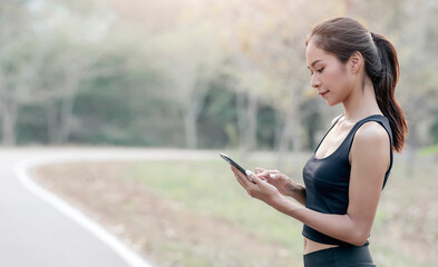 Young beautiful woman in sportswear using smartphone outdoors.