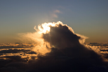 spectacular sunset seen from an airplane with clouds in the foreground and in the distance
