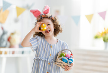 child with Easter painting eggs