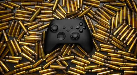 Modern black gamepad on a black background among the spent cartridges. Game concept. Shooter game. © solidmaks