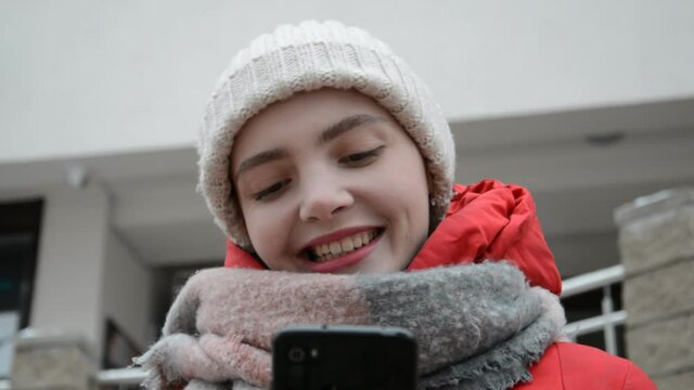 Close up face of student girl texting with friends in online chat on smartphone outdoor