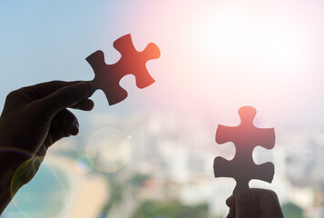 Autism and autistic ,child putting puzzle together. Hands of children students holding pieces of...