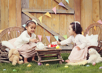 Two girls enjoying an Easter themed tea party in the garden