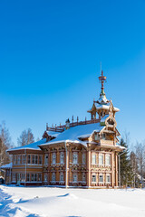 Restored old traditional russian wooden house ("Astashovo terem") with ornamental carved windows and frames. Winter sunny day. Chukhloma, Kostroma region, Russia. Kostroma famous landmark.