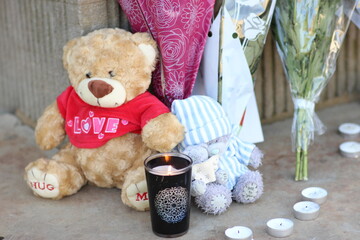 Big and small teddybears with bouquets of flowers and candles