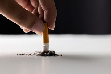 Close up hand putting out a cigarette. man extinguished his cigarette by crushing the floor. He...