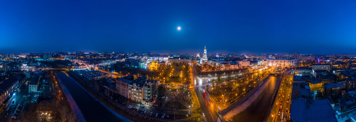 Wide winter aerial panorama of embankment of Lopan river with view to Holy Dormition Cathedral - Uspenskiy sobor, and night panorama of Kharkiv city, Ukraine