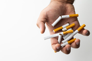 A young man crushed cigarettes with his hand. Because he wants to quit smoking. World No Tobacco Day.