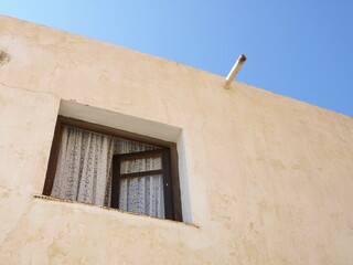 Ventana y desagüe de canalón en una fachada encalada de una aldea del mediterráneo andaluz © Franjagoher