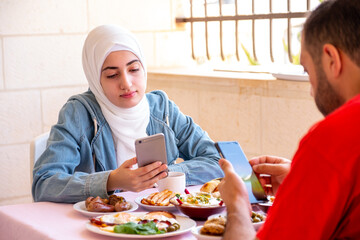 Couples are eating breakfast but busy with their phones
