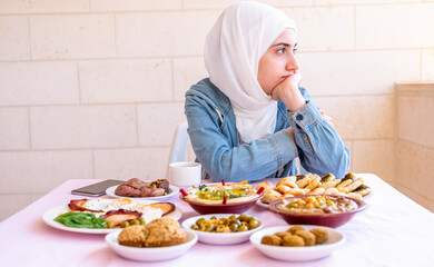 Muslim girl is thinking while eating her breakfast