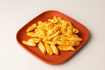 Crispy penne pasta shaped salty. Fast food or junk food snacks unhealthy concept.