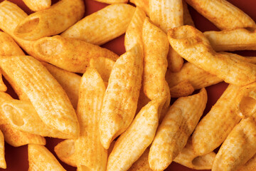 Crispy penne pasta shaped salty. Fast food or junk food snacks unhealthy concept.