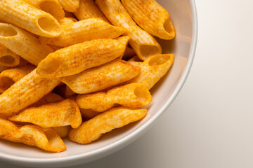 Crispy penne pasta shaped salty. Fast food or junk food snacks unhealthy concept.