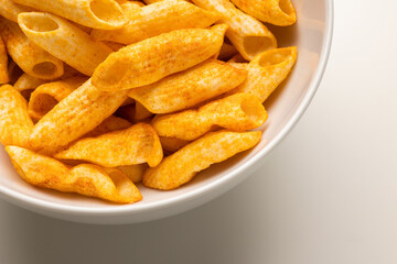 Crispy penne pasta shaped salty. Fast food or junk food snacks unhealthy concept.