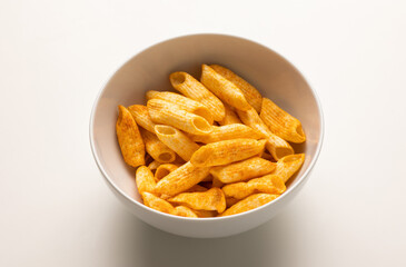 Crispy penne pasta shaped salty. Fast food or junk food snacks unhealthy concept.
