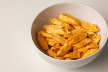 Crispy penne pasta shaped salty. Fast food or junk food snacks unhealthy concept.