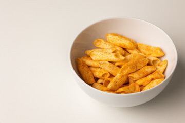 Crispy penne pasta shaped salty. Fast food or junk food snacks unhealthy concept.