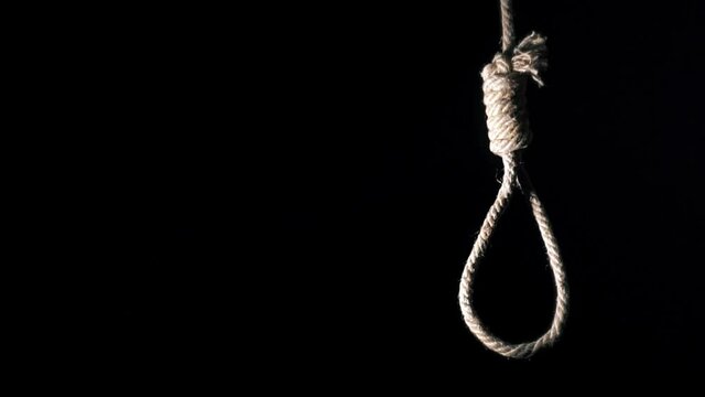 Rope noose with hangman knot in front of dark background. suicide loop