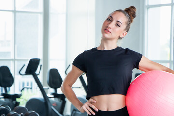 portrait caucasian white woman smiling happily and holding a yoga mat and exercise ball