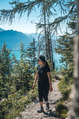 Fototapeta premium Girl with a hat climbing, hiking down from mount Schoberstein and looking down to the Lake Atter (Attersee) in the alps, Austria