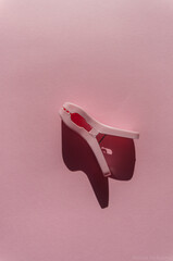Pink  clothes peg on pink background