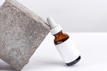 Close-up serum essence in glass bottle on stand background. Isolated skincare oil