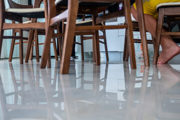 Table and the reflection of chairs and boy's legs