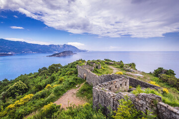 Fototapeta premium Mogren Fortress near Budva town on the Adriatic shore, Sveti Nikola Island on background, Montenegro