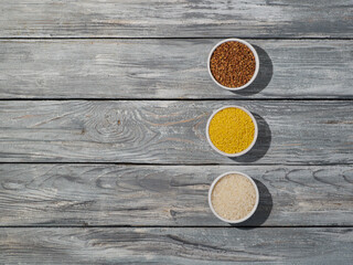 Set of groats in the bowls on wooden background.