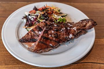 Argentine cut of meat called Entrana with vegetables and served on a white plate