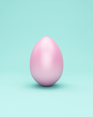 Pink easter egg on turquoise studio background