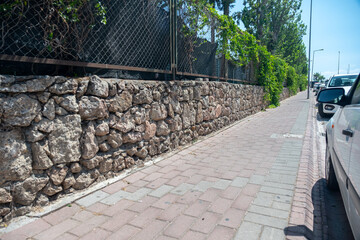 Sidewalk for peoples in modern design beside some parked cars