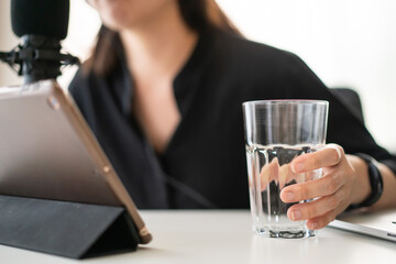Happy Asian woman setting up a living room in her house for podcast studio.