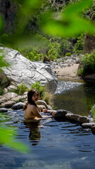 Fototapeta na wymiar Young girl looking back while relaxing in hot springs