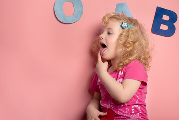 Proper articulation therapy for girl  of 2-3 years. Speech therapy concept over pink  background