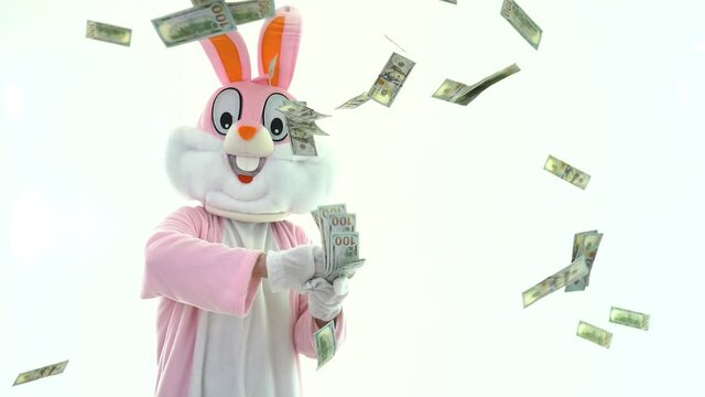 Rich lucky funny man millionaire businessman scatters dollars, throws money USD banknotes. Happy Easter Bunny. Money rain, falling dollars isolated. Finance concept
