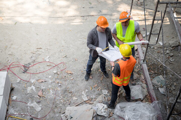Confident team of architect working together in building construction site. They discussing about new startup project. Architect discuss with engineer about project . Architectural concept.