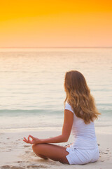Fototapeta na wymiar Yoga woman on beach at sunset